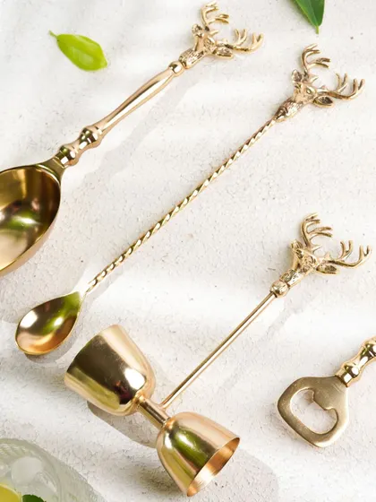 A flat-lay of an elegant, brass bar set, showcasing each piece of the collection in a beautifully arranged composition.