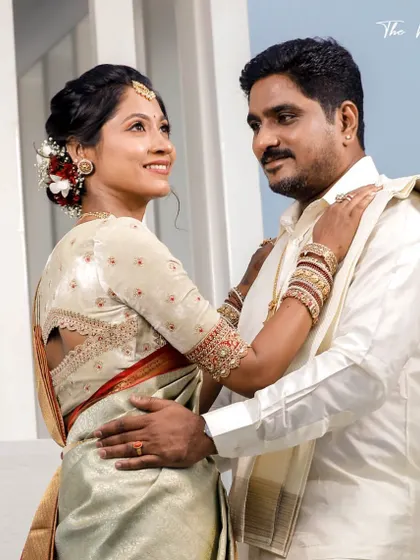 A bride in a light green and red Kanchipuram saree. Her custom off-white blouse features a unique back cutout and delicate embroidery.