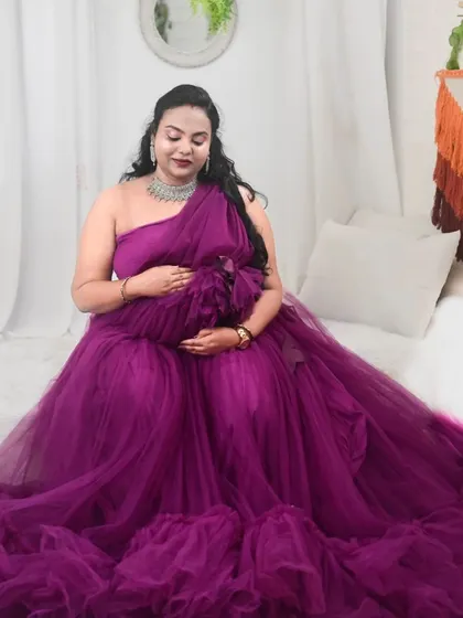 This one-shoulder purple gown with a full, layered skirt is a stunning option for an indoor maternity photoshoot.