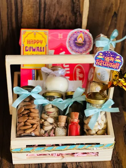 An overhead shot of the open wooden crate Diwali hamper, showing the colorful assortment of sweets and nuts.