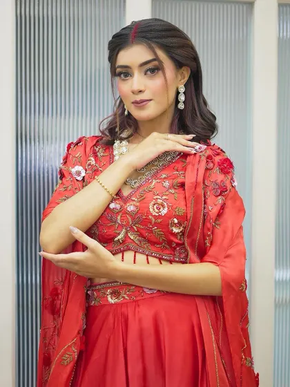 A beautiful Karva Chauth look featuring a modern red ensemble. The makeup is soft yet festive, with defined eyes and a hint of sindoor, perfectly blending tradition with contemporary style.