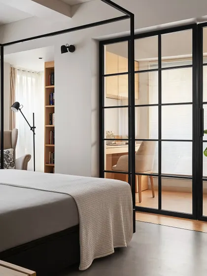 The master bedroom in Zen House features our custom four-poster bed in black ash wood. The room is zoned into sleeping, study, and reading areas, with a transition from concrete to wood flooring to define the cozier corners.