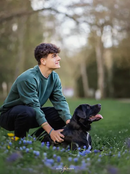 A young man and his best friend, sharing a quiet moment in a field of flowers. The bond between teenagers and their pets is just as strong and important to capture.