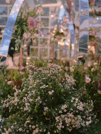 A close-up of the dreamy fresh florals used in the mirrored arch mandap. The soft textures and colors of the baby's breath and other wildflowers created a delicate contrast with the modern structure.