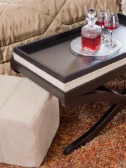 A close-up of the padded bench, showing the texture of the neutral fabric and the elegant, dark-finished wooden frame. It's a versatile piece that adds a layer of comfort and style.