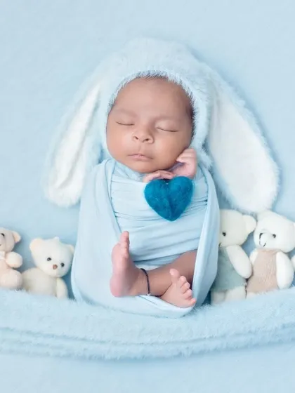 A sweet baby bunny holding a blue heart, nestled among his teddy bear friends. This shot is full of love and sweetness.