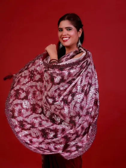 The swirl of a saree captured in motion. This shot is full of life and energy, showcasing the beautiful drape and sparkle of the fabric against the bold red.