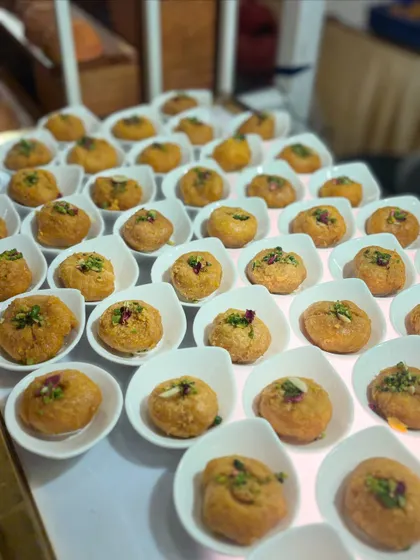 A beautiful array of a classic Indian sweet, likely a type of peda or milk-based dessert, garnished with nuts and ready for serving.