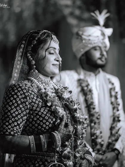 A serene black and white photo taken during the ceremony. The bride's peaceful expression as she soaks in the moment, with her groom in the background, creates a timeless and emotional image.