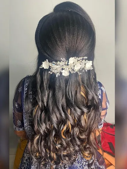 A chic and modern reception hairstyle. This half up style features soft waves and is adorned with a beautiful silver and white floral hair accessory.