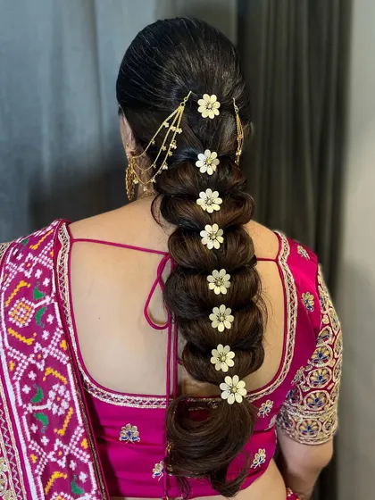 Another angle of the floral pull-through braid, showcasing the craftsmanship and how each accessory is perfectly placed. This is a great Indian bridal braid style for long hair.