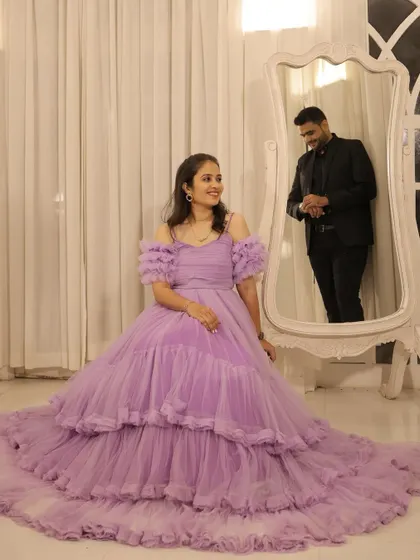 A whimsical indoor photoshoot featuring a lavender tiered gown. The setting with the ornate mirror adds a touch of fairytale romance.