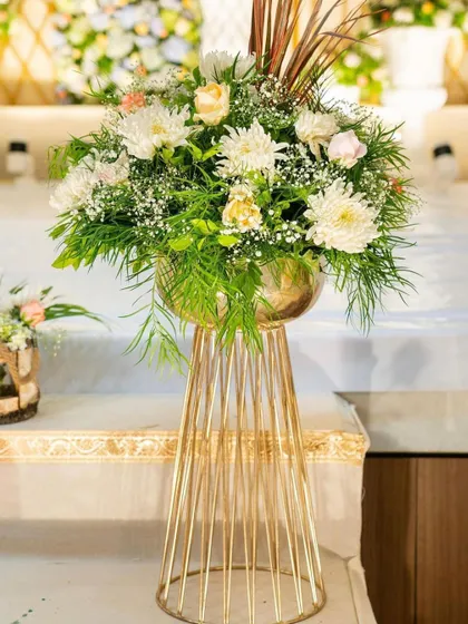 An elegant floral centerpiece on a modern gold stand. These arrangements are perfect for decorating tables or lining walkways at any sophisticated event.