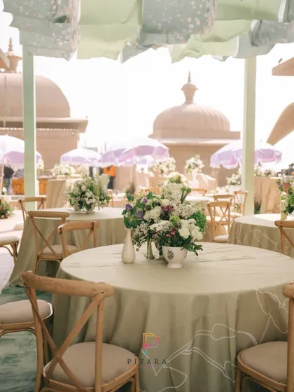 A closer look at the pastel green dining setup, with the heritage domes in the background adding a touch of grandeur to the breezy, daytime event.