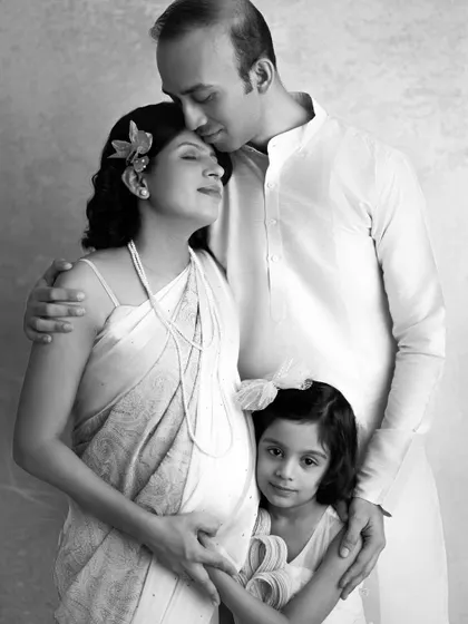 A timeless black and white family portrait. The way her husband and daughter hold her close shows the love surrounding this new baby. This is what togetherness looks like.