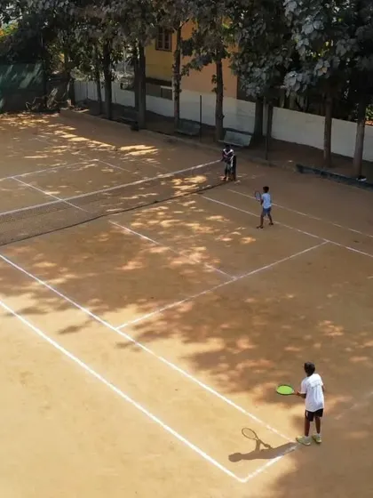 An aerial view of our courts shows players of different ages enjoying their lessons, highlighting our commitment to coaching for all.