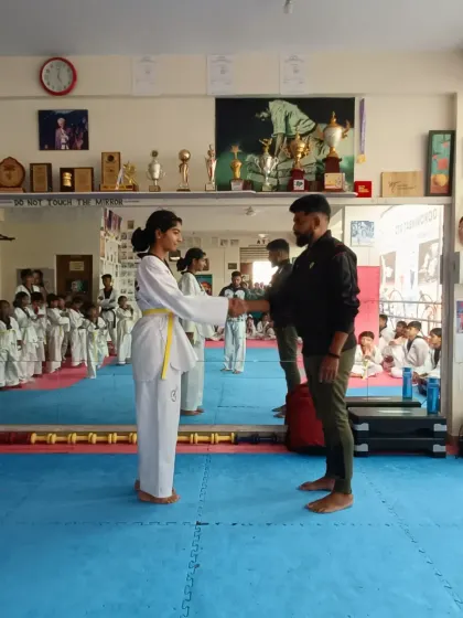 A student receives her yellow belt.