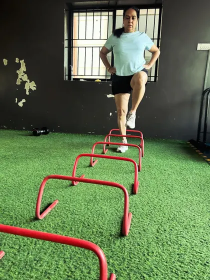 A client steps over mini hurdles, a drill that improves hip mobility and coordination.