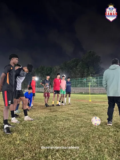 Players focused on the coach's instructions during a night session, demonstrating their discipline and eagerness to learn.