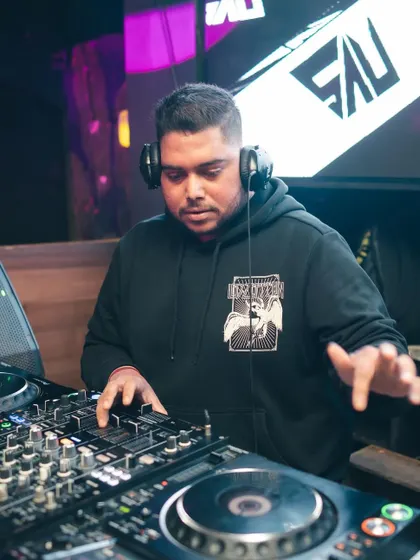 At the helm at Flamiingo Lounge, with my logo on the screen behind me. I bring a professional brand and top-tier equipment to every venue.