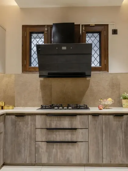 This Gurgaon kitchen is a testament to the perfect blend of style and practicality, with sleek laminate cabinets and a modern black chimney.