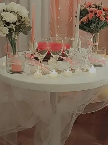 A close-up of a romantic table setting for two, with wine glasses, candles, and flowers, perfect for an anniversary or proposal dinner.