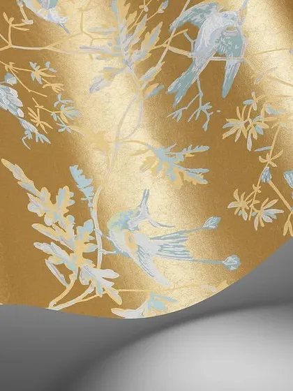 A detailed view of the Hummingbirds wallpaper from Cole & Son. The metallic gold finish catches the light beautifully, while the finely illustrated birds in soft blue and white create a sense of movement and grace, showcasing the design's intricate artistry.
