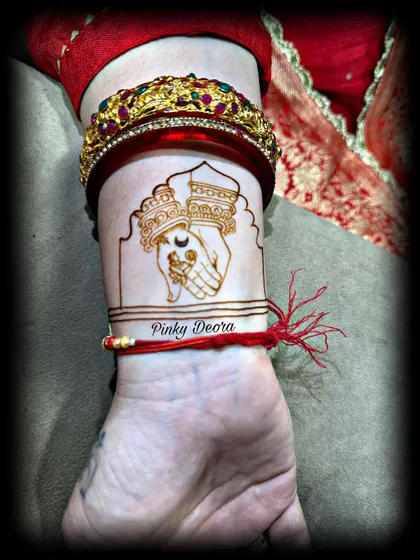 A minimalist yet meaningful Karwa Chauth design on the wrist. It depicts the ritual of exchanging water, symbolizing the bond and care between partners.