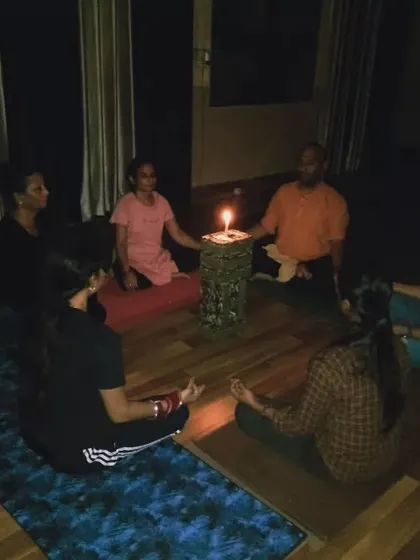 The serene, low-lit environment of our Trataka meditation session. Practicing in a group creates a powerful collective energy that enhances the focus and stillness for everyone involved.