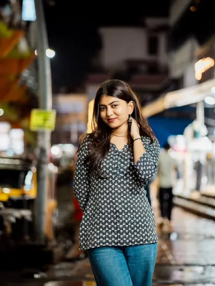 A confident and engaging pose. The way she's holding her hands and looking at the camera is very natural.