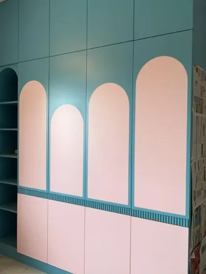 We love playing with shapes and colors. This custom wardrobe features a playful design with pink arched panels against a teal base, adding a touch of whimsy and personality to the room.