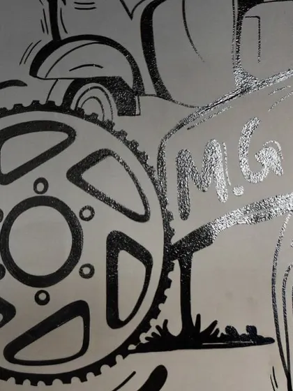 A macro shot showing the clean line work and silver-painted details on the M.G. Road sign from our cafe doodle project. Precision is key in our hand-painted murals.