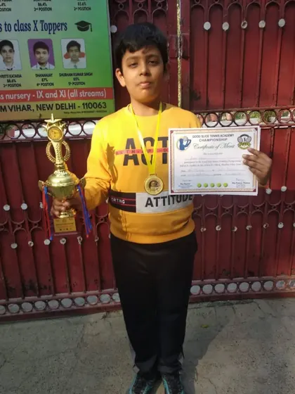 A young champion from the Good Slice Tennis Academy tournament holding his trophy and certificate. We train players to be competitive from a young age.