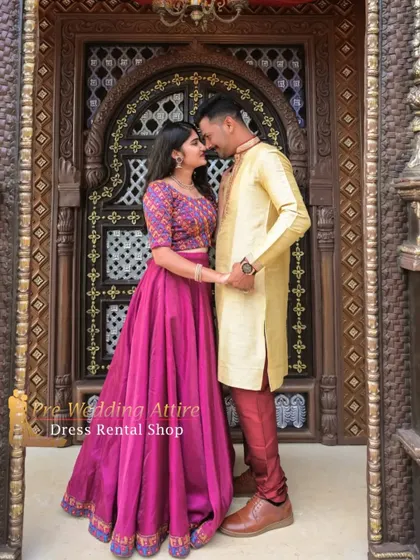 This couple's outfit combines a vibrant magenta crop top and skirt with a simple yet elegant golden-yellow kurta set. This shows how you can mix and match bright, festive colors for a lively and celebratory pre-wedding shoot.