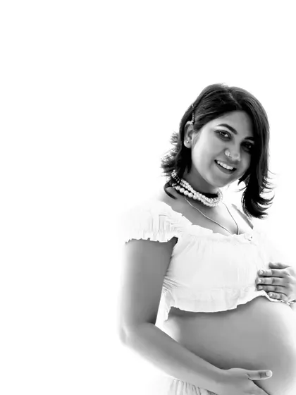 A bright and airy high-key portrait. This black and white photo has a fresh and modern feel, beautifully capturing the mom-to-be's happy glow.