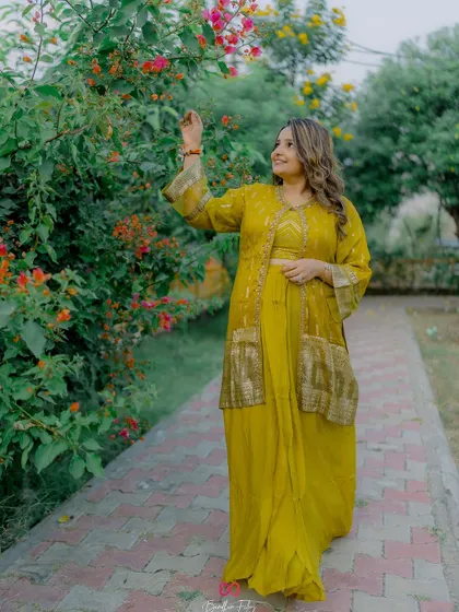 The bride enjoying a quiet moment in a garden during her Haldi ceremony, looking radiant in her yellow attire.