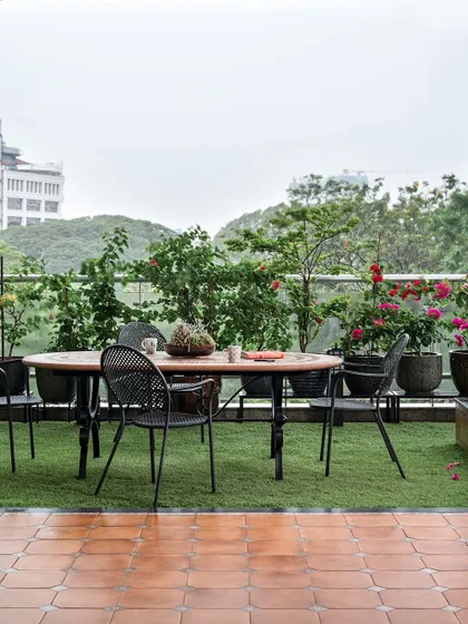 The outdoor deck combines earthy terracotta tiles with a green turf area, providing a serene escape with beautiful city views.