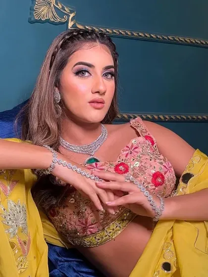A relaxed and stylish pose in the floral lehenga, highlighting the diamond-look jewellery and the vibrant yellow dupatta.