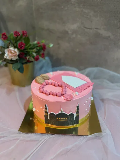 A pretty pink Ramadan cake for a little girl, decorated with a mosque silhouette, prayer mat, and tasbeeh.