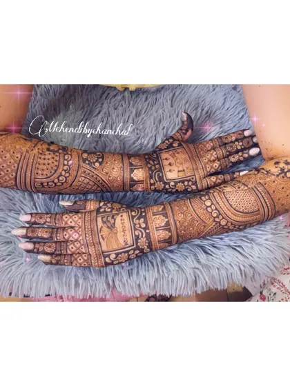 A full view of the bridal arms, covered in personalized portraits and intricate patterns. This is the ultimate storytelling mehendi for a bride who wants it all.