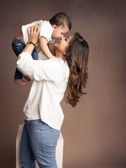 A mother lifts her baby boy high in the air, sharing a moment of pure joy and laughter. These candid, playful shots are filled with so much life.