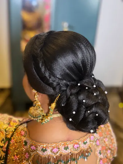 Another variation of a classic bun, this time with a side twist and scattered pearls. It's an elegant and sophisticated choice for any formal event.