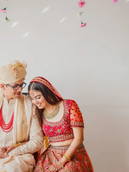 A quiet, happy moment between the bride and groom, seated together during their intimate home wedding.