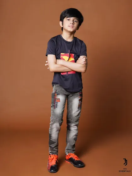 A classic pose for a kids' clothing catalogue. The simple setup ensures the focus remains on the apparel and the model's cool attitude.