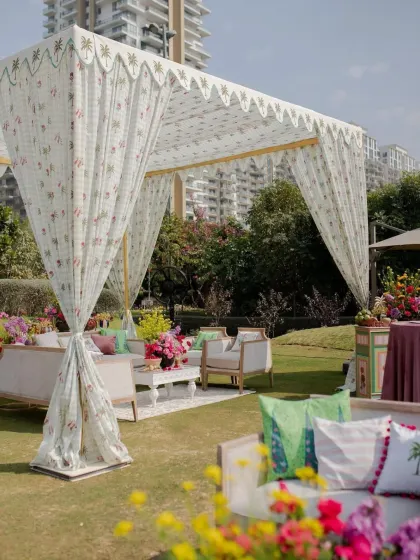 Another view of the lounge tent, showing how the printed fabric, colorful cushions, and floral arrangements work together to create a cohesive and stylish look.