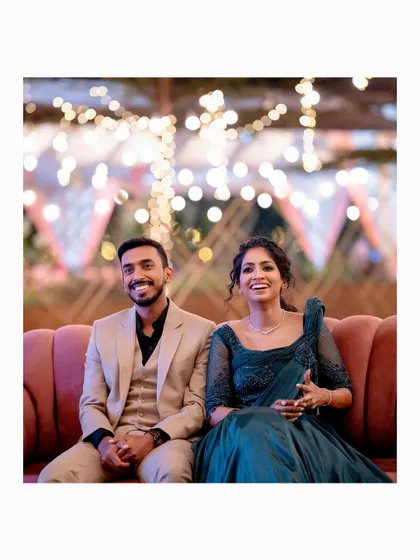 A candid shot of the couple enjoying the performances at their Sangeet, with beautiful bokeh lights in the background.
