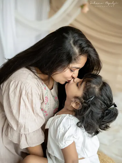 A sweet and gentle kiss between a mother and her daughter. This tender moment, captured in a soft and dreamy setting, is a memory to be cherished forever.