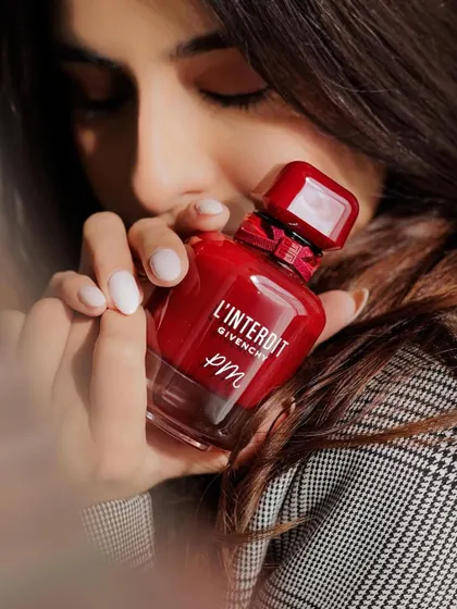 A close-up of the personalized Givenchy bottle, held by an influencer. My work often ends up in the hands of creators, and it's great to see it styled so beautifully.