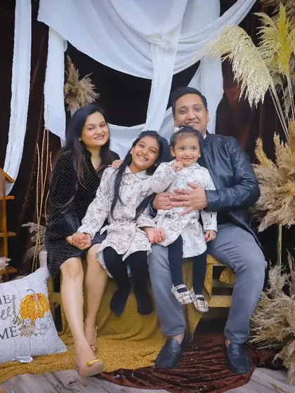 The family of four seated on a bench in our autumn-themed boho studio setup.