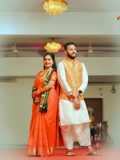 A stylish portrait of the couple in traditional Maharashtrian attire. They stand back-to-back, creating a modern pose while wearing classic wedding outfits.